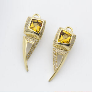 A pair of gold earrings with yellow stones.