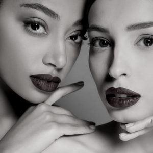 Two women with dark lipstick posing for a picture.